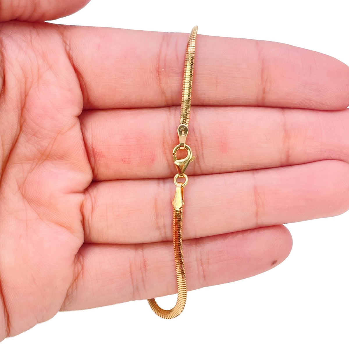 Lobster clasp fastening on 22ct yellow gold snake chain bracelet